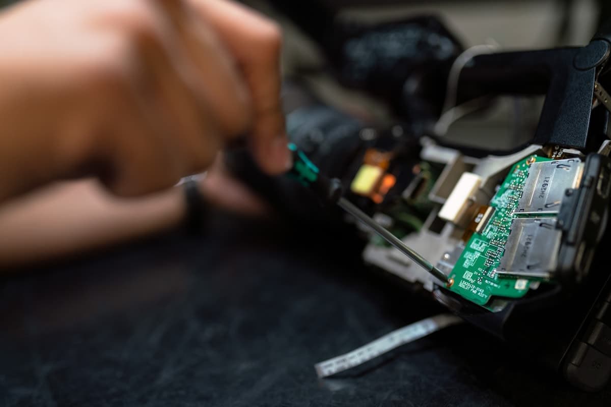 Techniker repariert elektronisches Gerät mit Schraubendreher