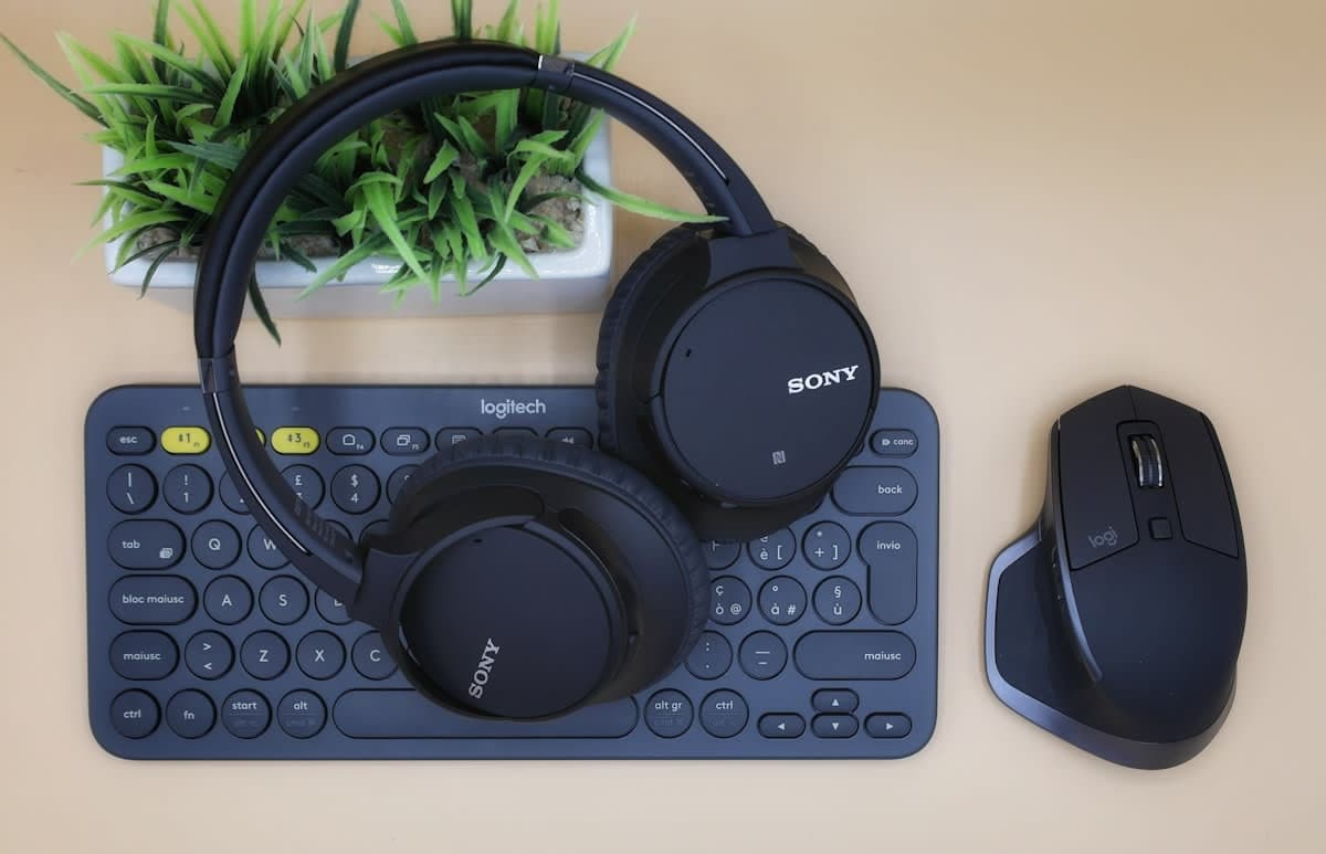 Elektronikprodukte wie Kopfhörer, Tastatur und Maus auf einem Schreibtisch