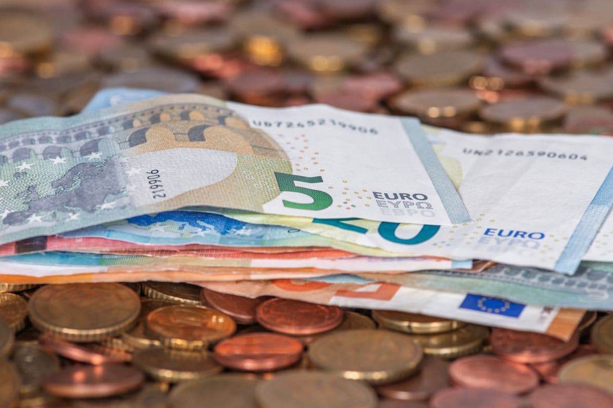 Euro-Banknoten und Münzen auf einem Tisch: gezählter Kassenbestand für das Kassenbuch