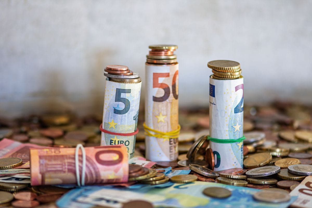 Gerollte Euro-Banknoten und Münzen auf einem Tisch beim Kassenabschluss