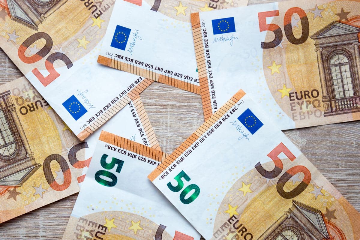 50-Euro-Scheine auf einer Holzfläche: Belegausgabe beim Bezahlvorgang